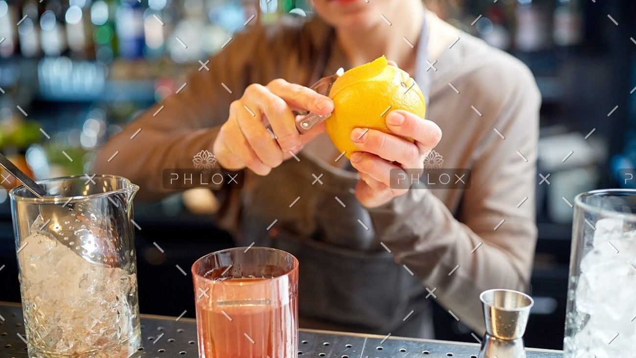 demo-attachment-18-bartender-peels-orange-peel-for-cocktail-at-bar-P97775Y