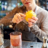 demo-attachment-18-bartender-peels-orange-peel-for-cocktail-at-bar-P97775Y